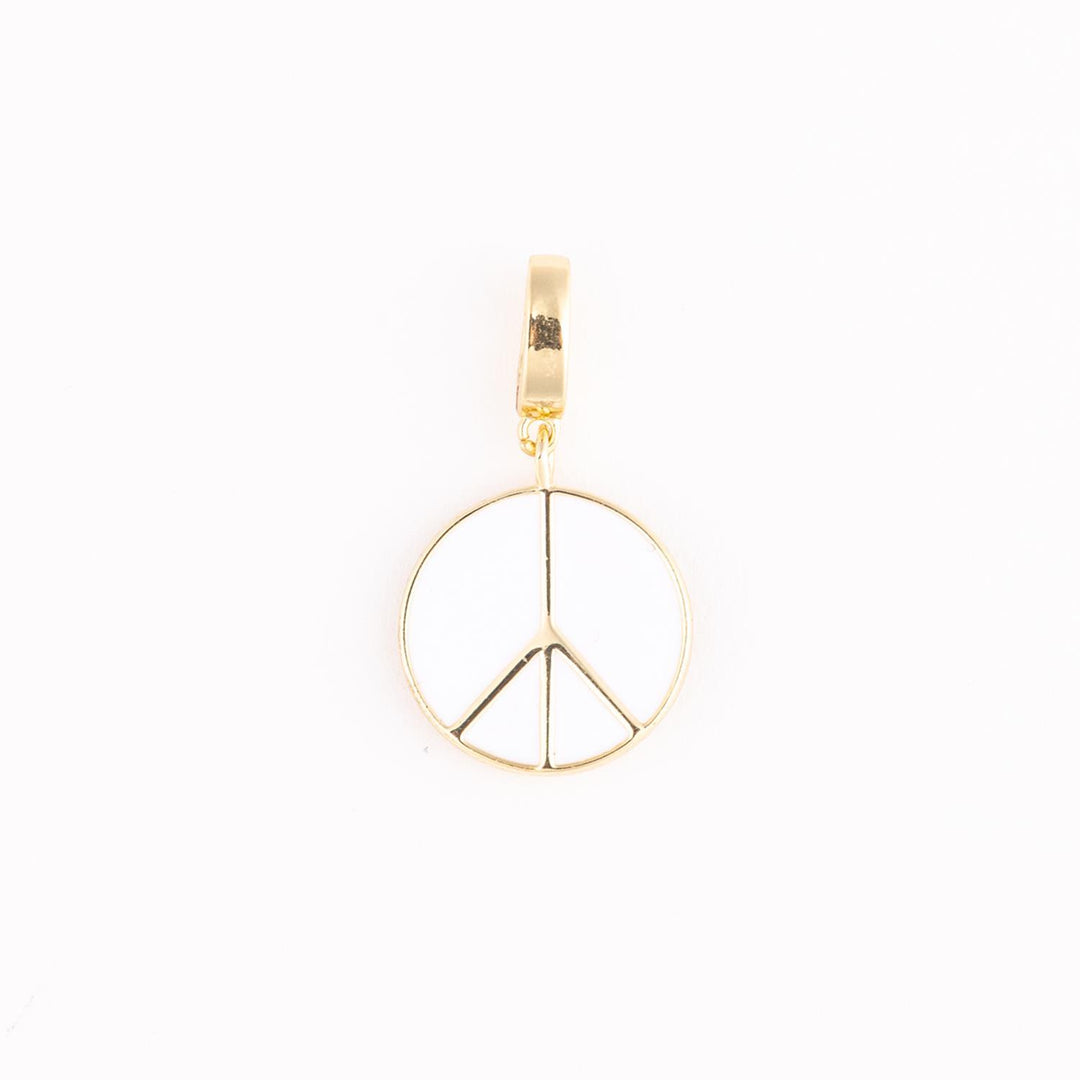 Gold and enamel jewelry pendant featuring a centered peace sign symbol with high-polish metallic edges, a smooth white inlay, and a reflective rectangular bail