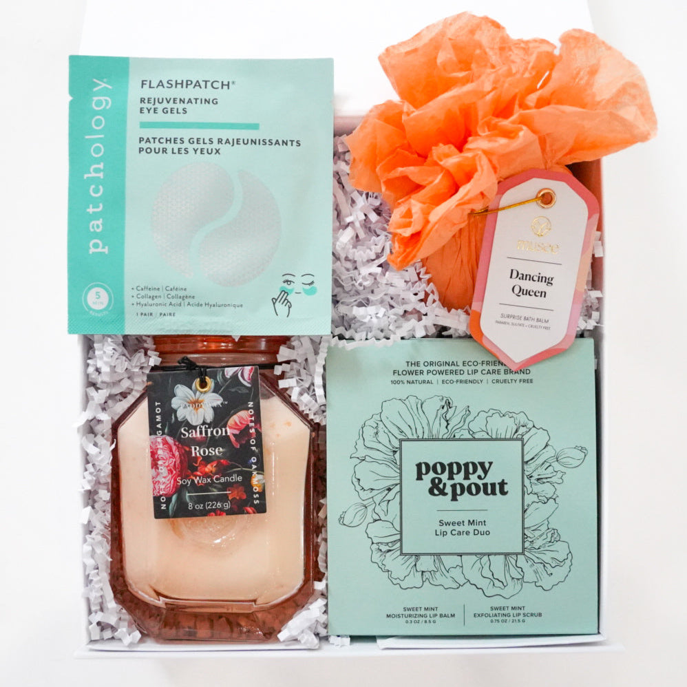 Gift set with skincare products and a loofah on a white background