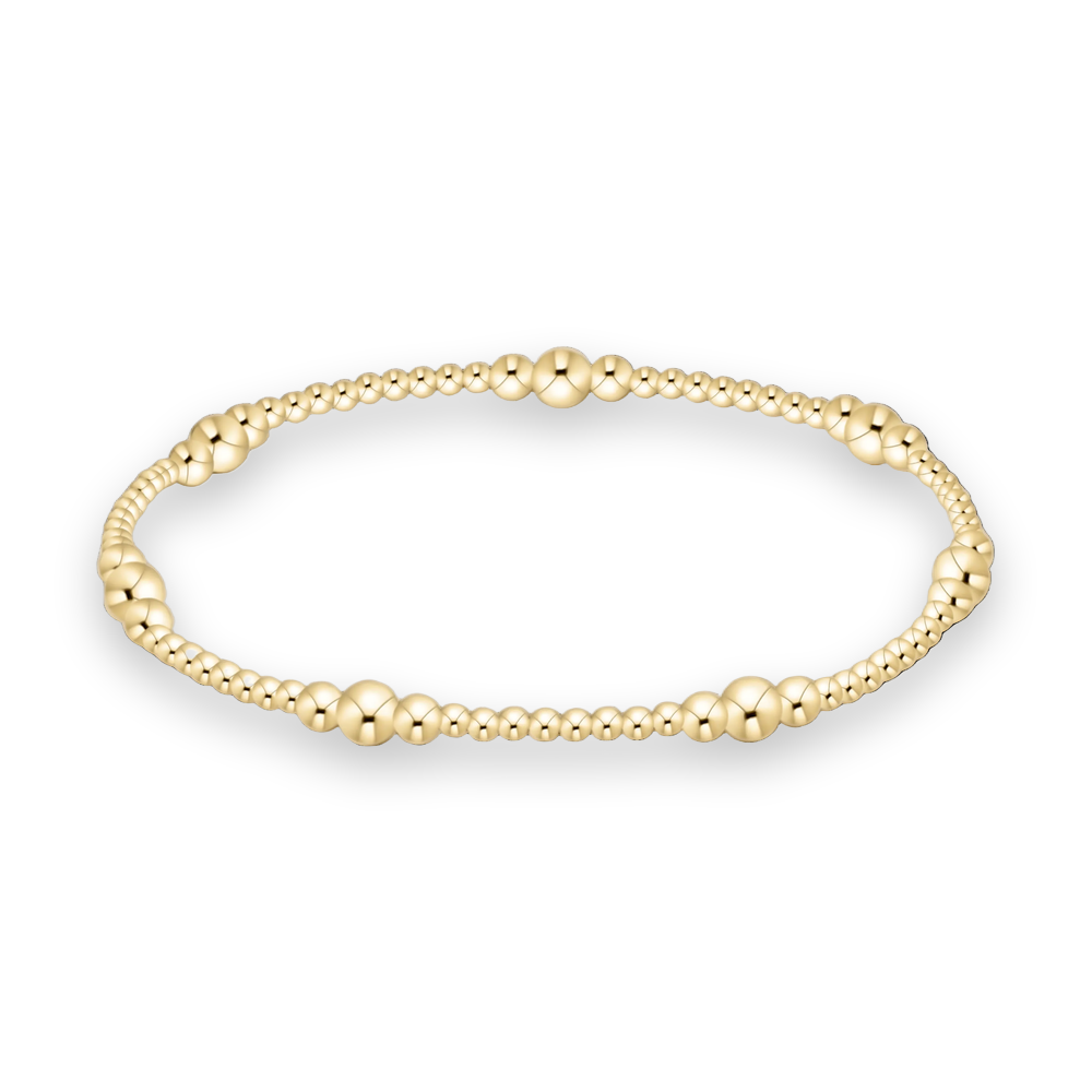 Yellow gold beaded bracelet featuring graduated polished spheres and brilliant mirrored highlights against a solid black background
