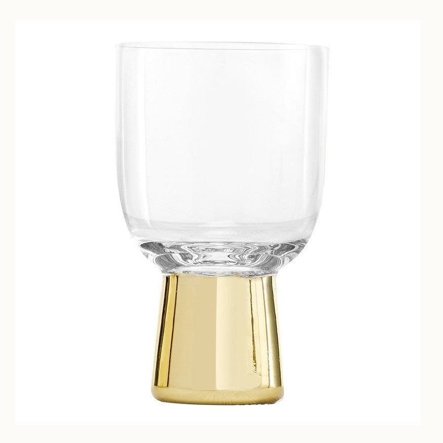 Mouth-blown glass by Tom Dixon features a Tank wine glass on a white studio background with a heavy hand-painted gold-toned pedestal base and a minimalist clear cylindrical bowl
