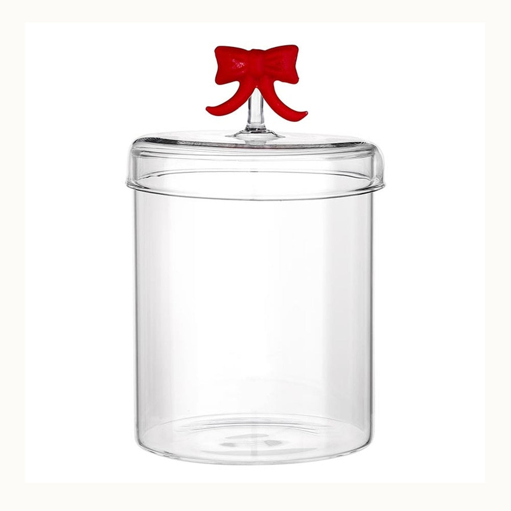 Transparent glass kitchen canister featuring a clear cylindrical base and a fitted lid embellished with a decorative bright red bow handle positioned against a clean white background