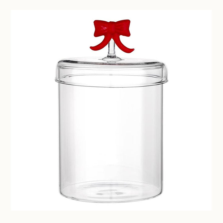 Transparent glass kitchen canister featuring a clear cylindrical base and a fitted lid embellished with a decorative bright red bow handle positioned against a clean white background