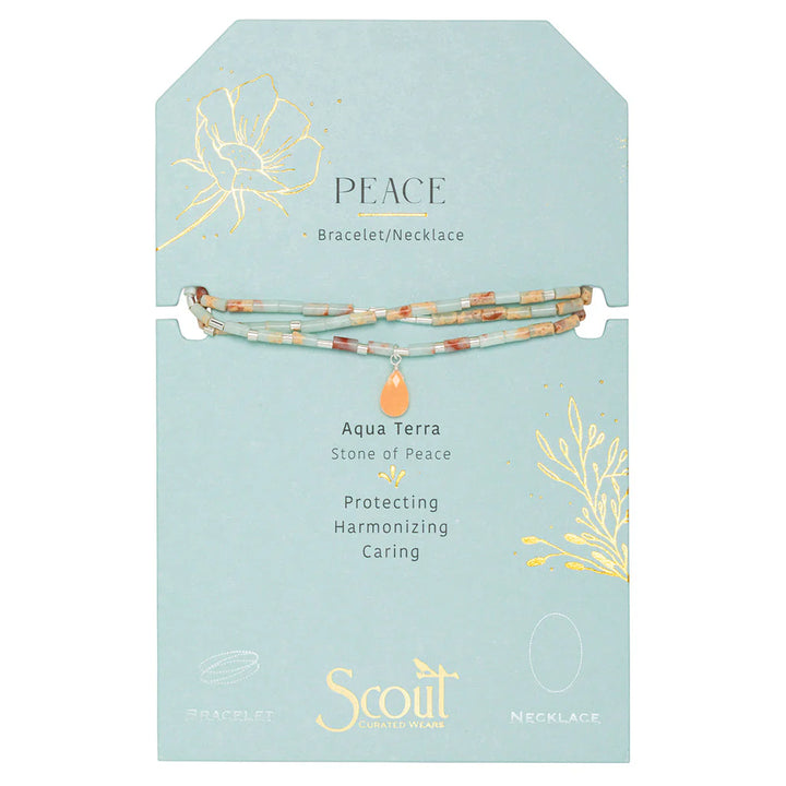 Handcrafted beaded jewelry by Scout Curated Wears featuring an Aqua Terra Stone of Peace necklace displayed on a light blue card with gold foil botanical illustrations and tiny cylindrical seafoam and terracotta beads surrounding a central peach teardrop charm