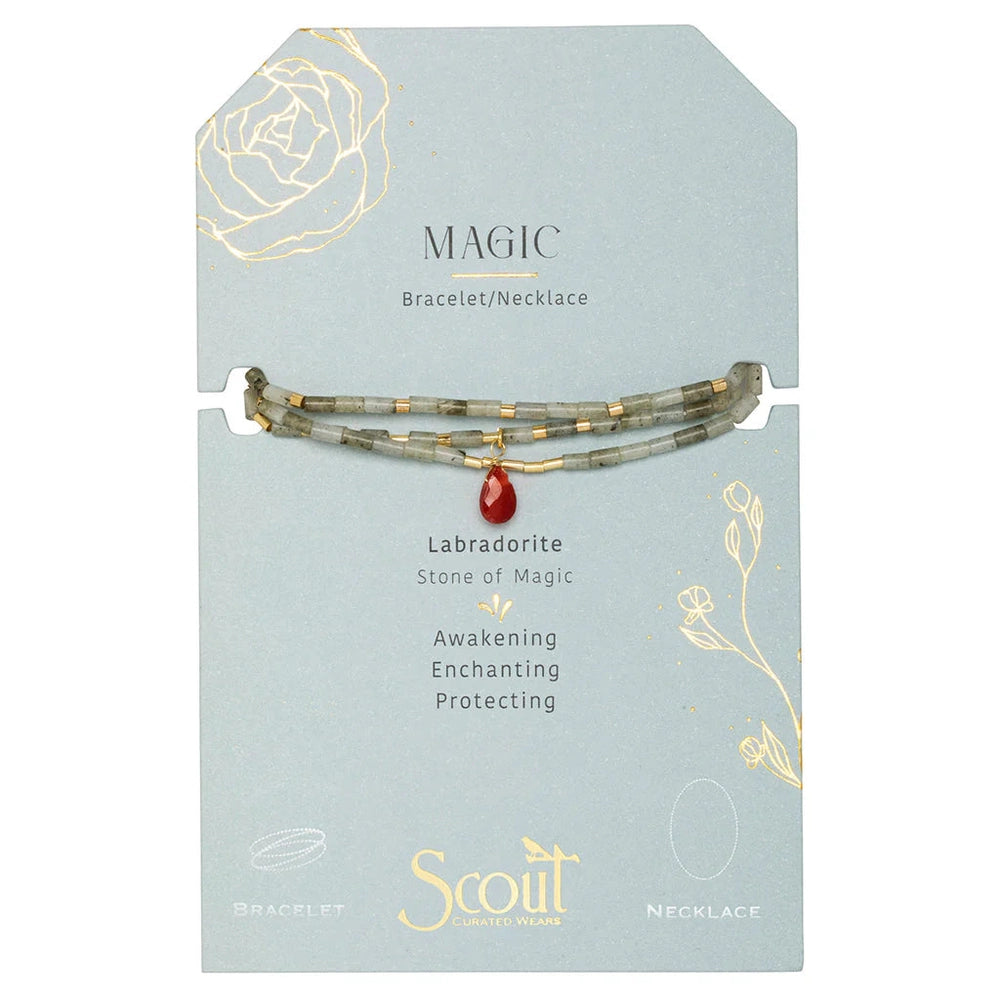Hand-beaded jewelry by Scout Curated Wears featuring a versatile labradorite bracelet or necklace on a light blue display card with gold foil floral sketches, iridescent gray stones, and a vibrant red teardrop charm