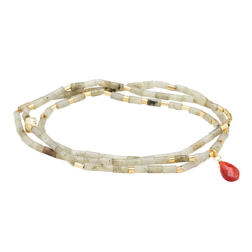 Handmade jewelry beaded wrap necklace on a white background featuring cylindrical light green stone beads, small gold-tone metal spacers, and a single faceted red teardrop gemstone pendant