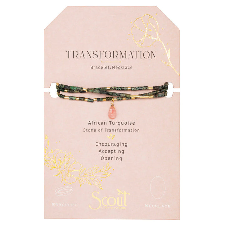 Jewelry by Scout Curated Wear featuring an African Turquoise beaded bracelet and necklace on a blush pink card labeled Transformation with mottled green stones, gold spacers, and a faceted pink teardrop pendant