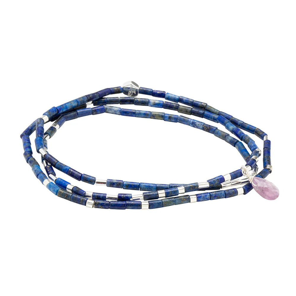 Handcrafted beaded jewelry featuring a multi-strand lapis lazuli wrap bracelet with metallic silver cylindrical spacers and a faceted pink teardrop charm on a plain white background