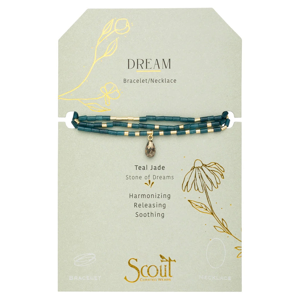 Jewelry by Scout Curated Wears presents a teal jade Stone of Dreams bracelet on a sage green card featuring gold floral illustrations, cylindrical matte beads, and a central faceted teardrop charm