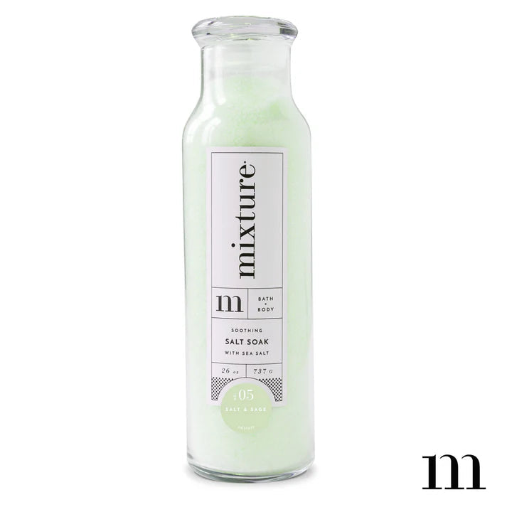 Product photograph by Mixture featuring a glass bottle of No. 05 Salt and Sage Soothing Salt Soak containing pale green crystalline sea salts and a minimalist white label with elegant black typography against a white background
