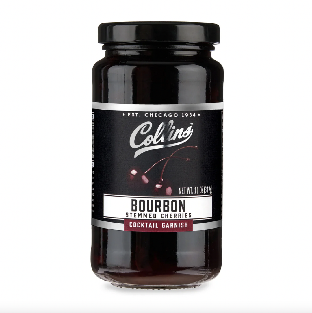 Studio photograph of a Collins Bourbon Stemmed Cherries glass jar centered on a white background featuring a black and silver foil label with Chicago branding and deep burgundy fruit visible beneath a black lid