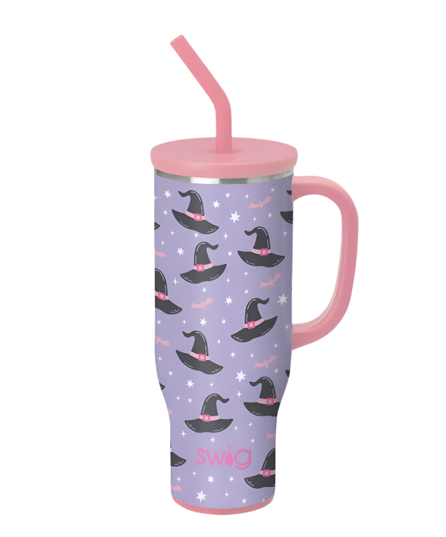 Swig Life stainless steel travel tumbler featuring a whimsical lavender pattern of black witch hats with pink buckles, twinkling white stars, and pink bats, complete with a coordinating pink handle and reusable straw set against a white background