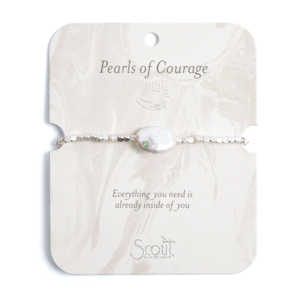Jewelry by Scout Curated Wears featuring a Pearls of Courage bracelet with a flat baroque pearl and small green gemstone on a silver beaded strand displayed on a marbled cream card with motivational text and a sun icon