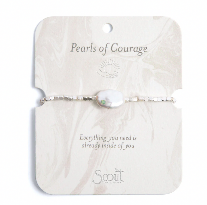 Jewelry by Scout Curated Wears featuring a Pearls of Courage bracelet with a flat baroque pearl and small green gemstone on a silver beaded strand displayed on a marbled cream card with motivational text and a sun icon
