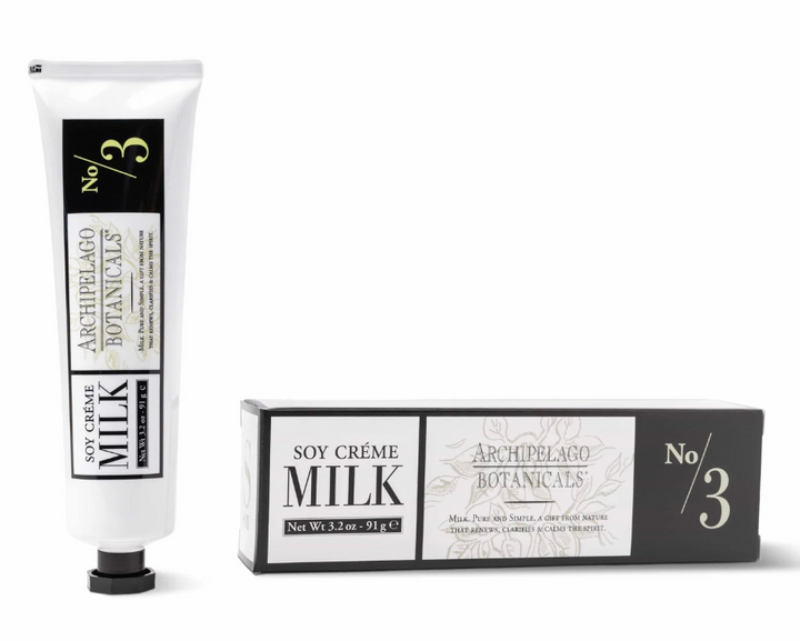 Product photography of Archipelago Botanicals Soy Crème Milk tube and coordinating box featuring minimalist black-and-white labels, delicate botanical sketches, and a prominent pale yellow No/3 graphic against a white studio background