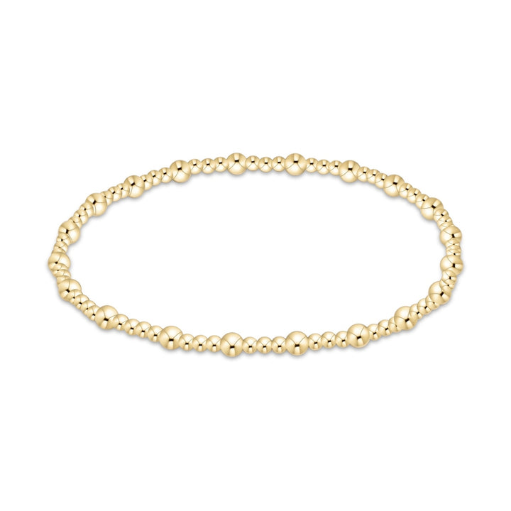 Gold beaded jewelry bracelet featuring alternating sphere sizes and a lustrous yellow finish centered on a minimalist white background
