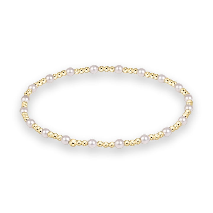 Gold and pearl beaded jewelry bracelet featuring an alternating pattern of small polished gold spheres and lustrous white pearls centered on a minimalist white studio background