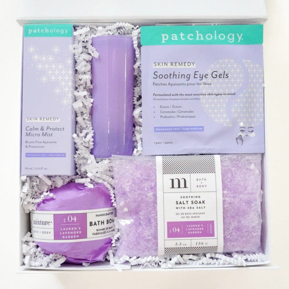 Photograph of a Patchology and Mixture curated spa gift box containing lavender-themed skincare including a purple candle, soothing eye gels, and Lauren's Lavender Garden salt soak crystals