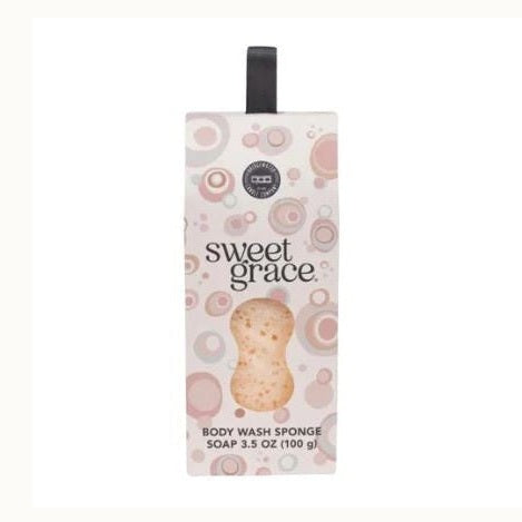 Product packaging by Bridgewater Candle Company for the Sweet Grace Body Wash Sponge soap featuring a pink and beige circular bubble pattern, a black fabric hanging strap, and an hourglass-shaped window revealing the textured sponge inside