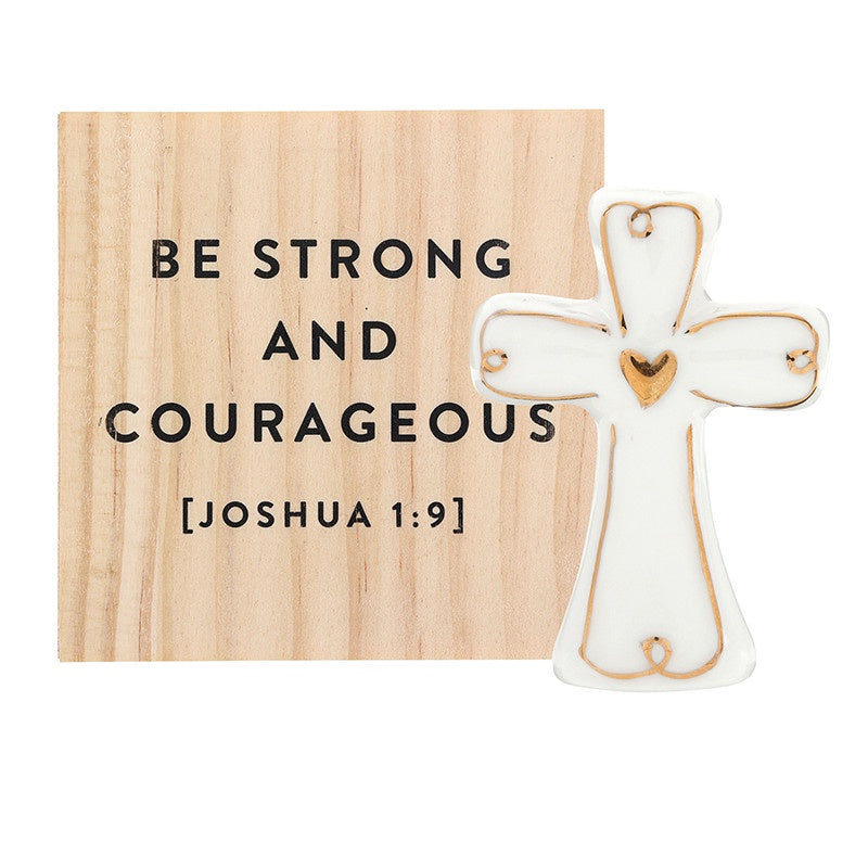 Wood and ceramic religious wall art featuring the scripture Be Strong and Courageous Joshua 1:9 on a natural pine block beside a white glazed cross with a gold heart and metallic gold trim