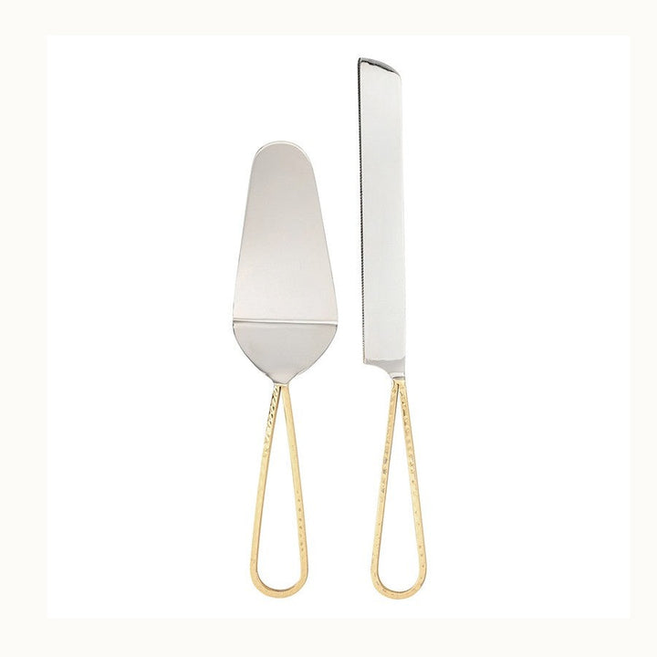 Polished stainless steel cake serving set featuring a server and serrated knife with elegant hammered gold-tone teardrop handles against a minimalist white background
