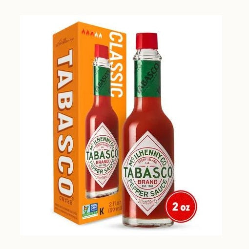 Commercial product photograph by McIlhenny Company of a 2 oz bottle of Tabasco Brand Pepper Sauce and its orange box on a white background, featuring the iconic diamond-shaped white label, a bright red screw cap, and green neck wrap