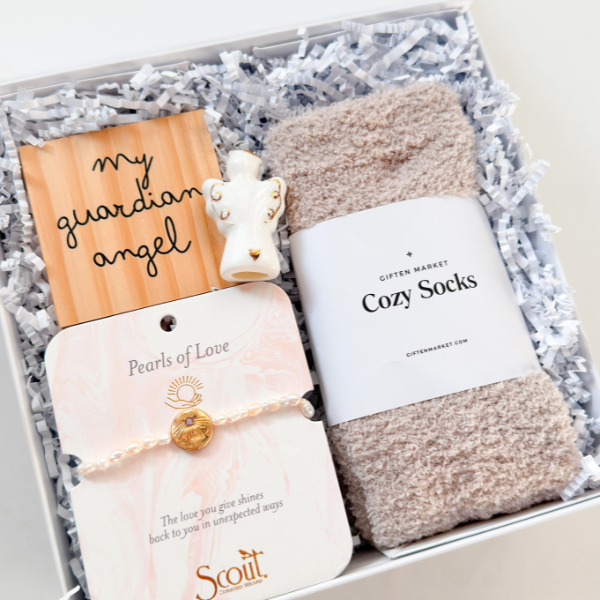 Gift set with 'My Guardian Angel' card, bracelet, figurine, and 'Cozy Socks' in a box.