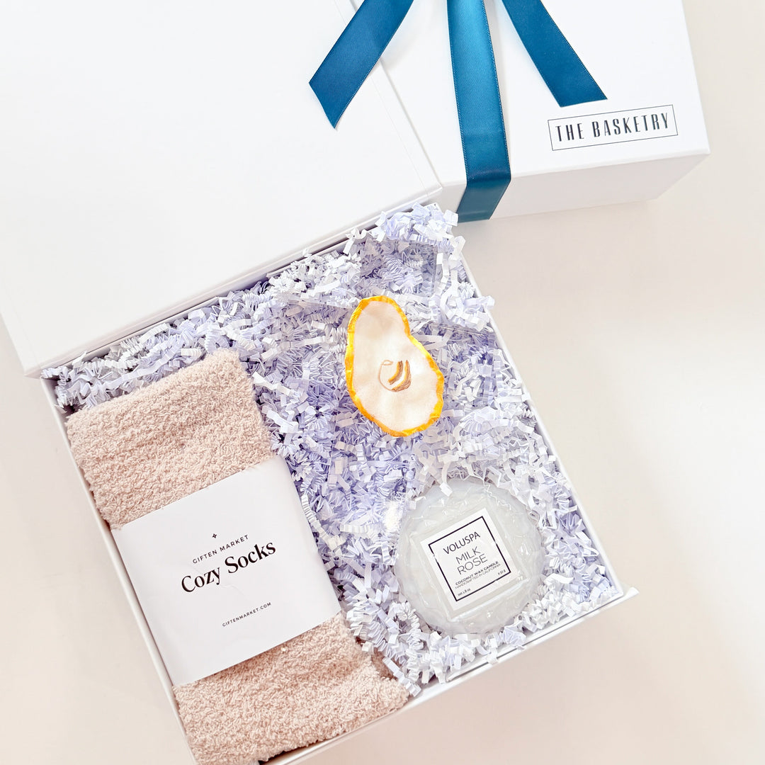 Gift set with cozy socks, candle, and bottle labeled &