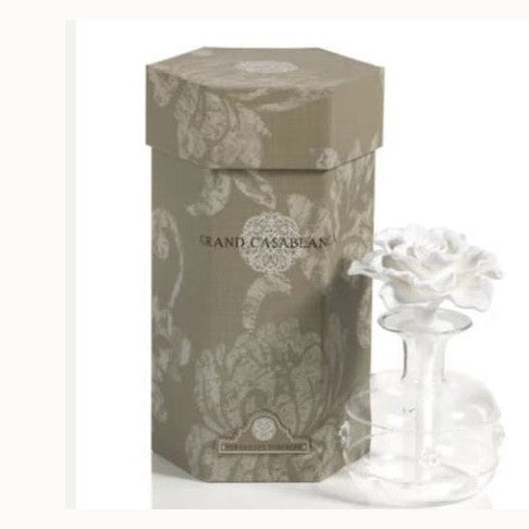 Product photography of an Aromatique Grand Casablanca fragrance diffuser set featuring a hexagonal taupe damask-patterned gift box and a clear glass bottle topped with a delicate white ceramic rose flower