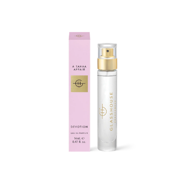 Studio product photograph by Glasshouse Fragrances of A Tahaa Affair Devotion Eau de Parfum featuring a 14mL clear glass spray vial with a metallic gold pump and a matching slim pink box with gold foil branding on a minimalist white background