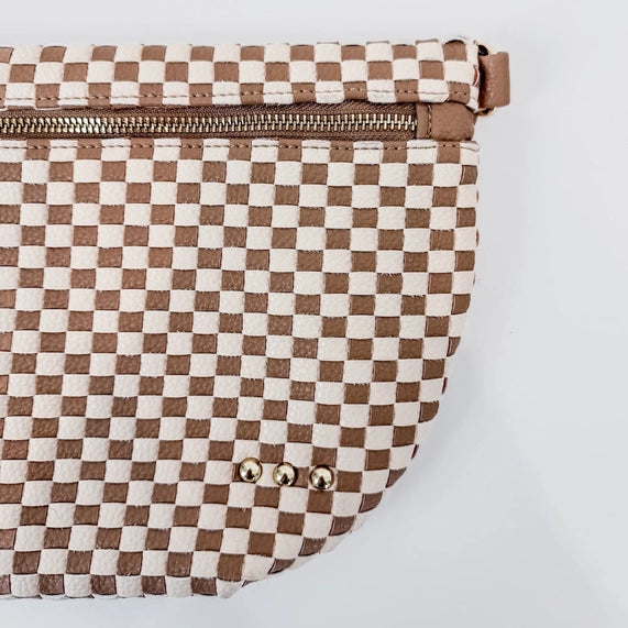 Woven leather pouch featuring a tan and cream checkerboard pattern with a brass top zipper and three decorative gold studs against a neutral white background