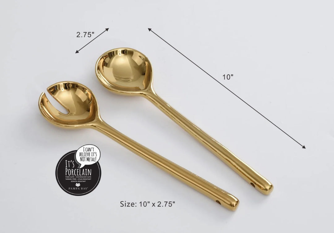 Pampa Bay titanium-finished gold porcelain salad servers featuring a serving spoon and a slotted fork set on a white studio background with dimensional measurement arrows, a circular Pampa Bay brand seal, and a brilliant reflective metallic luster