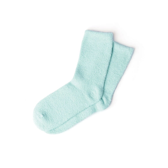 Studio photograph of a pair of mint green fuzzy socks centered on a white background highlighting their soft plush texture and cozy overlapping design