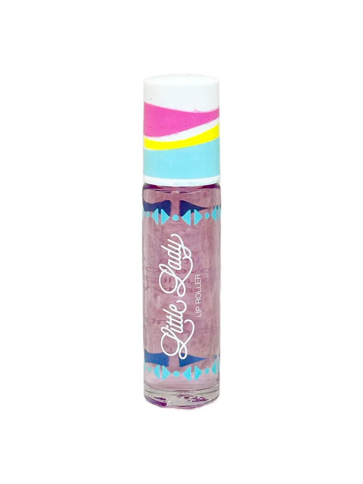 Product photograph of a Little Lady Lip Roller against a white background featuring a colorful cap with pink and yellow wavy stripes, a clear tube of purple translucent liquid, and blue geometric patterns framing the white cursive logo