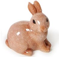 Polished stone rabbit figurine by an unknown artist sitting on a white studio background featuring a mottled peach-toned texture, glossy finish, and small dark eyes
