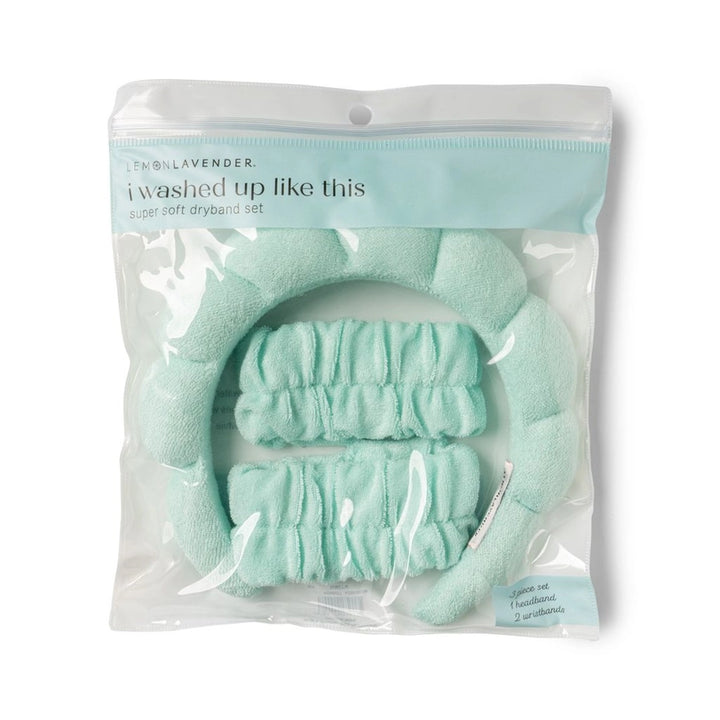 Product photography by Lemon Lavender of a mint green super soft dryband set in clear plastic packaging featuring a puffy quilted headband and two matching wristbands with the printed text i washed up like this