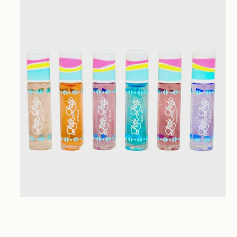 Product photography for Little Lady features six shimmering lip roller tubes in a row on a white background showcasing vibrant shades of teal and orange with colorful wavy striped caps and a distinct white script logo