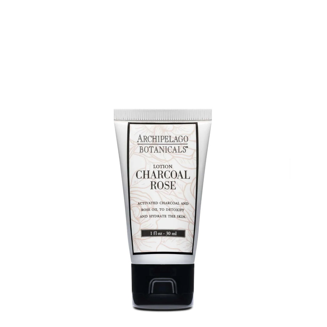 Studio photograph by Archipelago Botanicals of a Charcoal Rose Lotion tube centered on a white background displaying the iconic brand logo above delicate pink floral line art and a sleek black flip-top cap