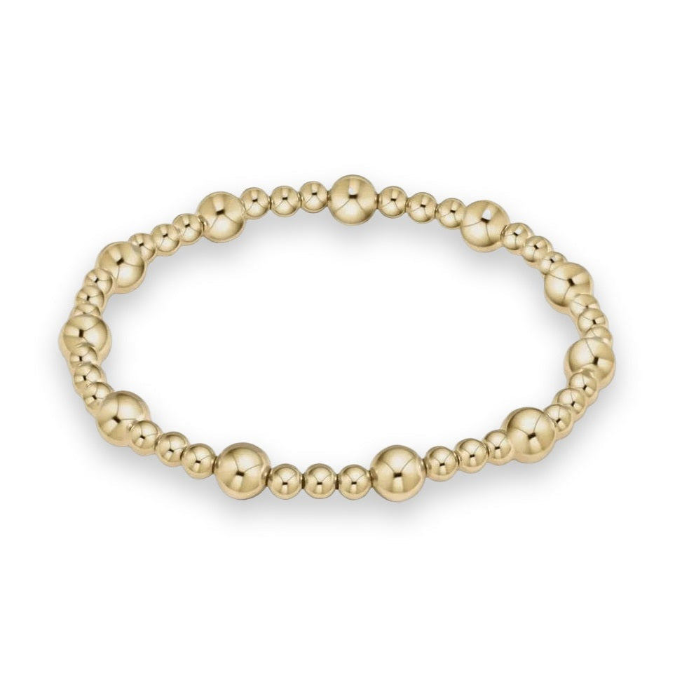 14k yellow gold beaded bracelet featuring highly polished spherical beads in alternating sizes and reflective surfaces against a neutral light gray background