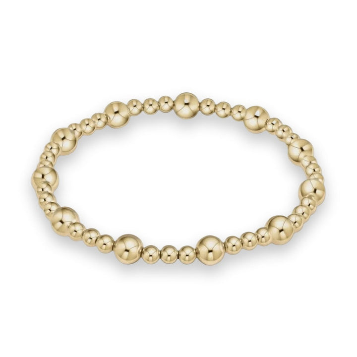 14k yellow gold beaded bracelet featuring highly polished spherical beads in alternating sizes and reflective surfaces against a neutral light gray background