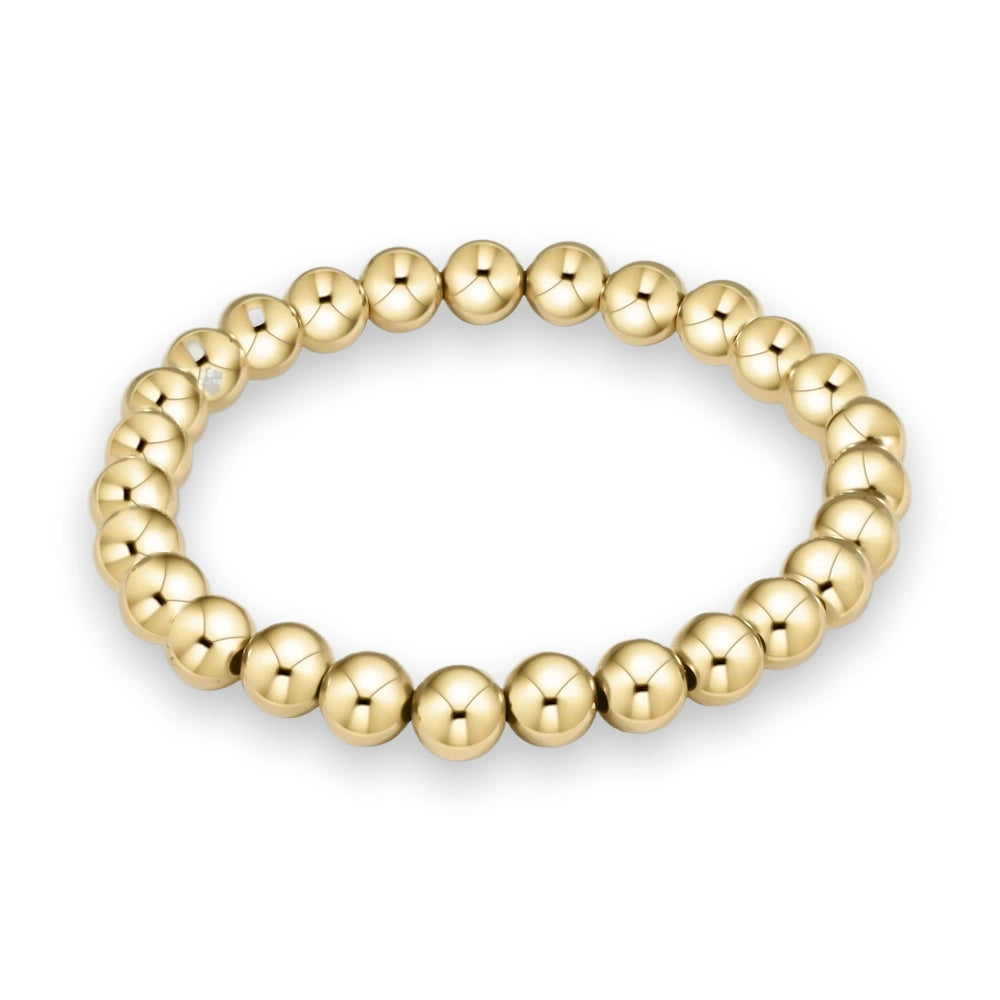 Gold bead bracelet featuring a seamless circular strand of uniform, highly polished spherical beads with a brilliant yellow-gold reflective finish centered on a minimalist white background