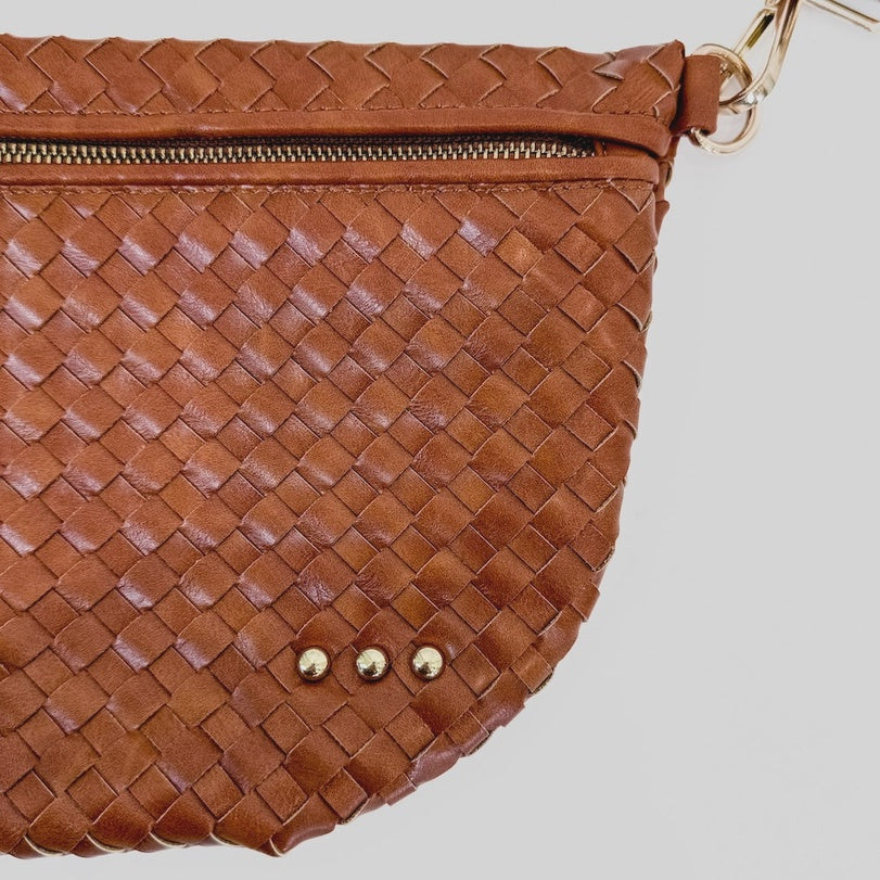 Woven leather brown handbag on a white background featuring a textured Intrecciato pattern, three small gold-tone studs, and a metallic zipper closure