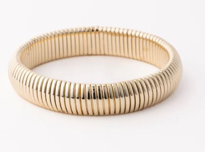 18k yellow gold Tubogas bracelet featuring a flexible coiled construction with a distinctive ribbed texture and a reflective high-polish finish set against a seamless white background