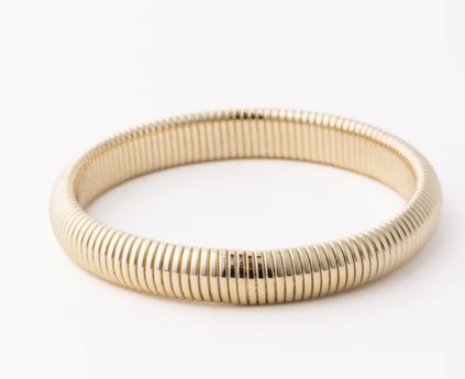Gold jewelry flexible Tubogas style bangle on a plain white background featuring a distinctive ribbed gas-pipe texture and a reflective polished finish