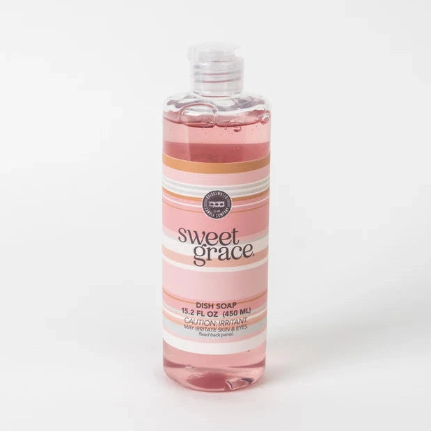 Studio photograph of Bridgewater Candle Company Sweet Grace dish soap displayed on a white background featuring translucent pink liquid inside a clear bottle with a pink and orange striped label and a flip-top cap