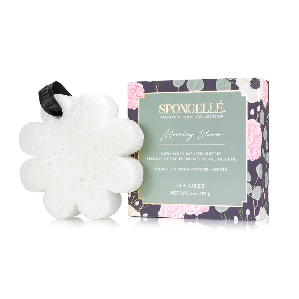 Product photograph by Spongellé of a Morning Bloom Body Wash Infused Buffer on a white background featuring a white flower-shaped sponge with a black branded ribbon and a dark green box illustrated with pink peonies and eucalyptus leaves