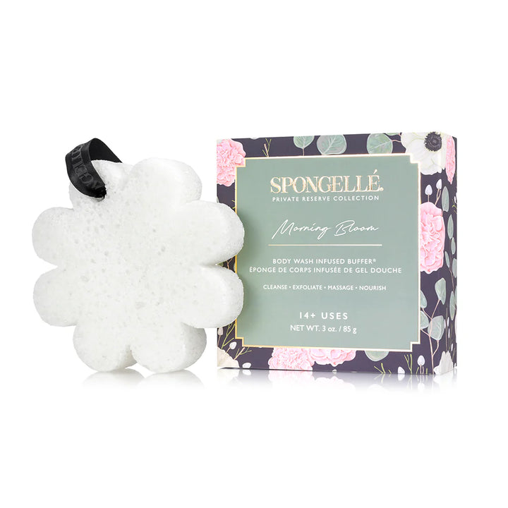 Product photograph by Spongellé of a Morning Bloom Body Wash Infused Buffer on a white background featuring a white flower-shaped sponge with a black branded ribbon and a dark green box illustrated with pink peonies and eucalyptus leaves