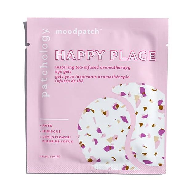 Product packaging by Patchology for Happy Place tea-infused aromatherapy eye gels depicts a light pink sachet on a white background highlighting a terrazzo-patterned eye patch design with purple, pink, and gold flecks and text mentioning rose, hibiscus, and lotus flower botanical extracts