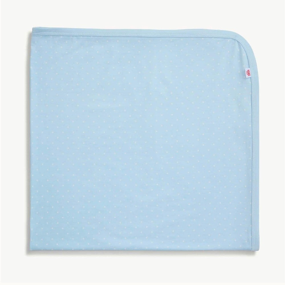 Cotton Monica + Andy baby blanket in light blue featuring a repeating tiny white polka dot pattern, a single rounded top corner, and a distinctive red logo tag on the edge