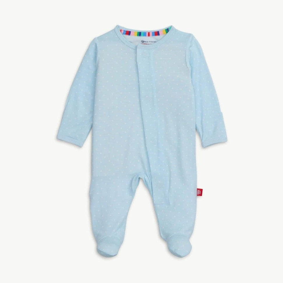 Digital product photograph of a Zutano baby footie pajama centered on a white backdrop featuring light blue fabric with white dots, a rainbow-striped inner collar, and a red brand tag