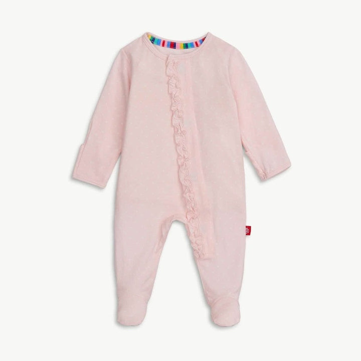 Product photograph of a pale pink baby footed sleeper centered on a white background featuring a delicate ruffle along the front zipper, a rainbow-striped inner neckline, and tiny white polka dots throughout the fabric